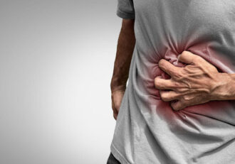 A person clutching their side in pain, resembling 'Can Gallstone Cause Elevated Liver Enzymes'.